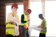 © Nikola Spasenoski - worker, investor, inspector or architect with her team. construction site engineers on site. satisfied expression