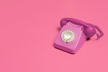 Pink Vintage Antique Rotary Phone On A Pink Background With Copy Space And Room For Text With A Right Side Composition.