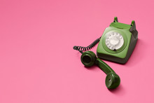 Green Vintage Antique Rotary Phone With Lifted Handset Receiver On A Pink Background With Copy Space And Room For Text With A Right Side Composition.