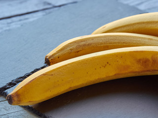 Ripe yellow bananas lie on a slate slab