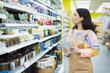 © Robert Daly/Caia Image - Female grocer with digital tablet checking inventory in supermarket