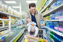 Father With Baby Daughter Shopping In Supermarket