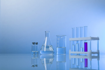 conceptual background with chemical flasks. blue backdrop with lab glassware with copy space. conceptual background of chemistry science in laboratory