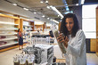 © Trevor Adeline/Caia Image - Woman shopping for pepper grinder in home goods store