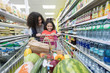 © Robert Daly/Caia Image - Mother and daughter shopping in supermarket