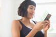 © Sam Edwards/Caia Image - Woman in bra using smart phone