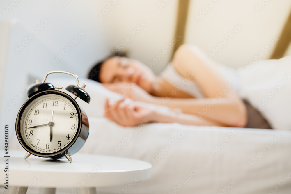 Alarm clock ringing.Woman waking up in early morning for work.Obstructive sleep apnea effects.Mental stress sleep depression.Melatonin deficiency.Narcolepsy.Burn out syndrome,overworked parent - obrazy, fototapety, plakaty 