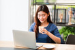 © chayathon2000 - Asian woman using computer laptop and drink coffee work from home concept