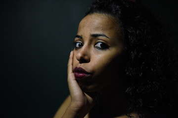 Wall Mural - young naked African woman posing at studio, face with hand portrait over dark background