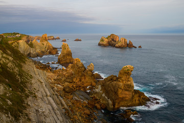 Wall Mural - Incredible cliffs on the coast near the village of Liencres before sunrise. Cantabria. Northern coast of Spain