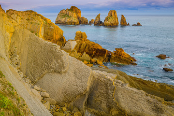 Wall Mural - Incredible cliffs on the coast near the village of Liencres before sunrise. Cantabria. Northern coast of Spain