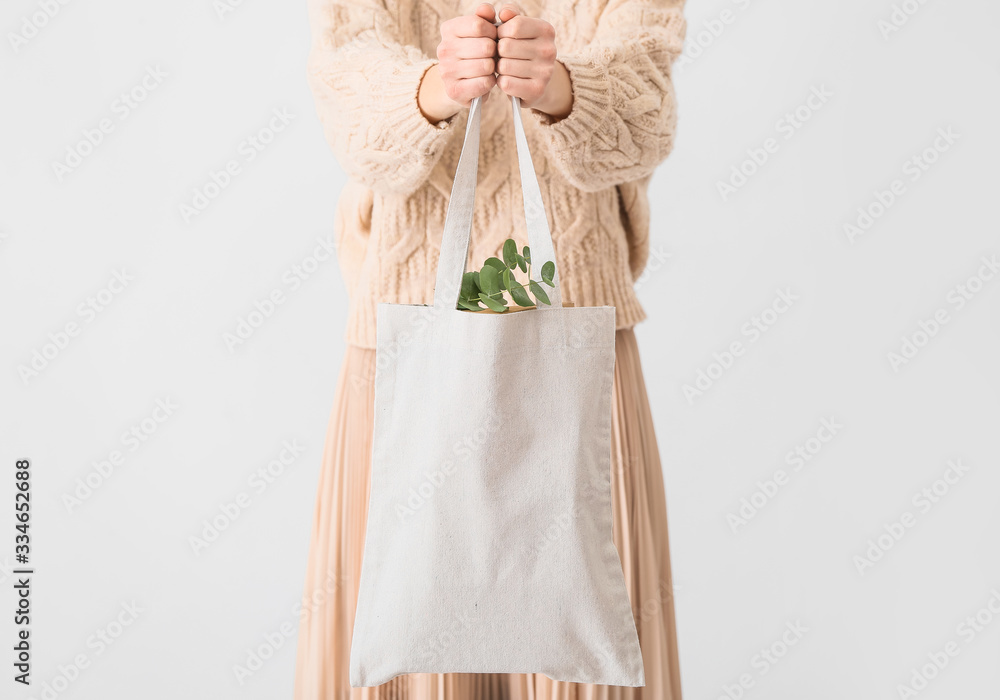 Woman with eco bag on light background