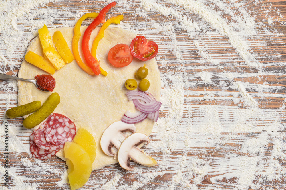 Ingredients for tasty pizza on wooden background