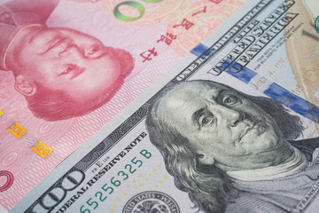 Global world economy crisis situation, US vs China trade war and currency war concept. US dollar and Chinese yuan renminbi banknotes background. US increases tariffs of Chinese goods.