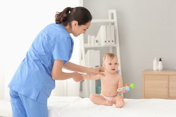 Poster - Massage therapist working with cute baby in medical center