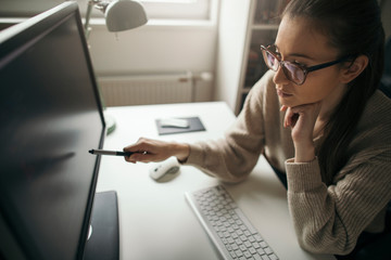 Wall Mural - Young business woman working on computer from her home