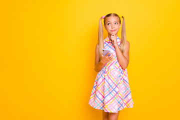 Poster - Photo of beautiful little lady hold telephone hand on chin look empty space think new post text ideas for youth blog wear checkered sun dress isolated bright yellow color background