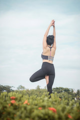 Young Asian woman practicing yoga in the park