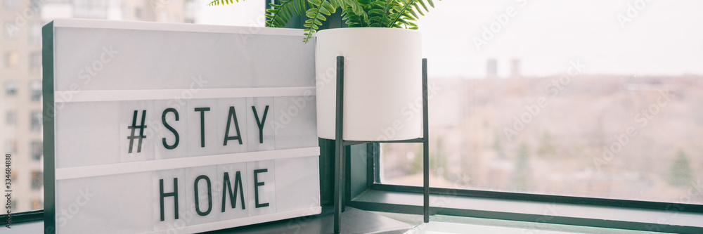 COVID-19 banner Coronavirus staying at home lightbox message sign with text hashtag #STAYHOME glowing in light to promote self isolation staying at home header background. - obrazy, fototapety, plakaty 