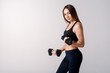 © Ilnur - Strong muscular girl working out with dumbbells. Photo of attractive sporty girl isolated on white background. Strength and motivation