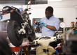 © JackF - Confident worker examines a broken motorcycle part of the working area
