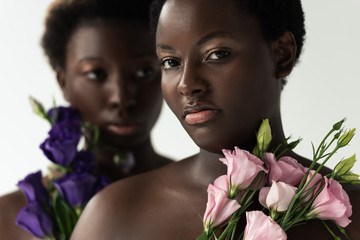 Wall Mural - selective focus of naked african american women holding pink and purple flowers isolated on grey