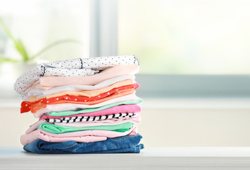 Wall Mural - Stack of cotton colorful clothes,folded clothing on table empty space.