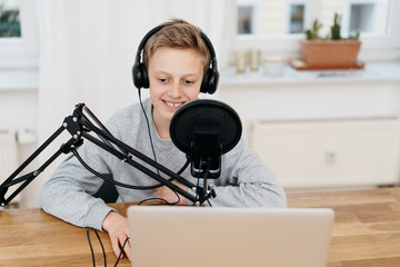 Wall Mural - Teenager sitting at computer with professional mic