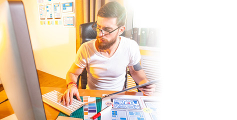 Wall Mural - ux design. man in a design studio. young guy works as a designer. application development for phones