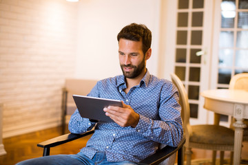 Wall Mural - Young man working from home on digital tablet