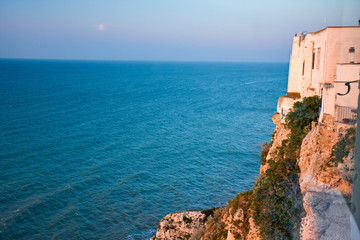 Village on a cliff overlooking the Mediterranean sea in sunset light.