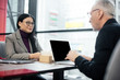© LIGHTFIELD STUDIOS - selective focus of smiling asian businesswoman talking with businessman in cafe