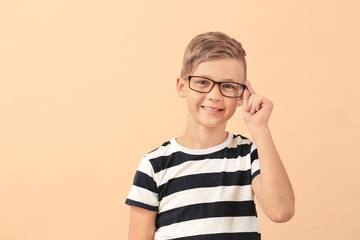 Wall Mural - Cute little boy with eyeglasses on color background