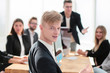 © ASDF - young employee sitting at a table during a business meeting