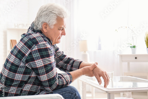 Fotomural Senior man suffering from Parkinson syndrome at home