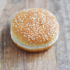 Wall Mural - wheat bun with sesame seeds on a wooden table hamburger ingredients