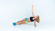 © Olga Rolencino - Concentrated beautiful fitness girl in sportwear exercising doing a side plank over white background. Copyspace