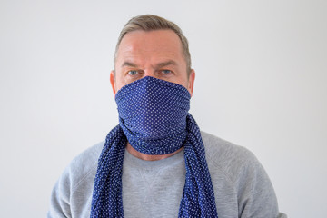 Bust portrait of man in blue scarf over his face