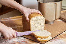 Hostess Cuts Loaf Of Bread With Big Knife