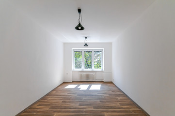 Empty room with white walls, wooden floor and window 