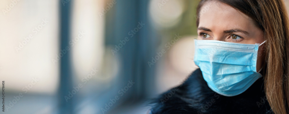 Young woman wearing disposable blue virus face mouth nose mask, closeup portrait - wide banner with space for text left side. Coronavirus covid-19 outbreak prevention concept - obrazy, fototapety, plakaty 