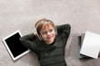 © New Africa - Cute little boy with headphones and tablet listening to audiobook on floor indoors, flat lay