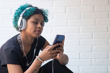 Portrait Of Young Woman With Mobile Phone And Headphones Listening To Music