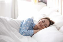 Young Woman Sleeping On Comfortable Pillow In Bed At Home
