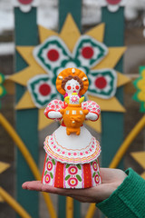 Ancient russian traditional national handcraft, handicraft - old dymkovo clay toy (doll): woman in russian folk style with samovar for tea drinking and kokoshnik. Best souvenir from Russia. Folk art