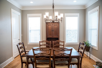 Formal Dining room with a set of wood table and chairs and a chandelier with windows and natural lights and hardwood floors