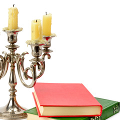 Candlestick with candles and book isolated on white background.