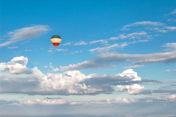 Hot air balloon flying in beautiful blue sky above clouds. Beautiful colorful background