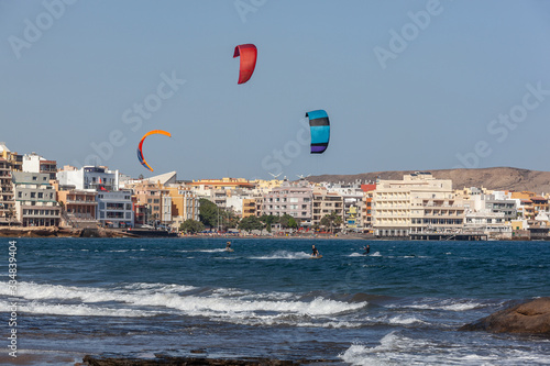 Fotomural Kite surfs at the volcanic beach towards the resort embankment in the bohemian village of El Medano, Tenerife, Canary Islands, Spain