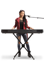Young Female Musician Playing A Keyboard And Singing On A Microphone